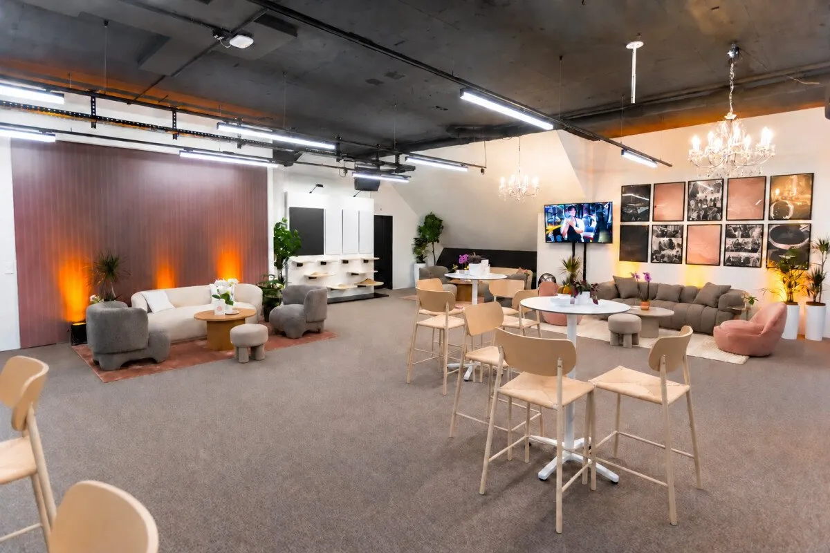 A lounge area with sofas, armchairs, high tables and warm lighting