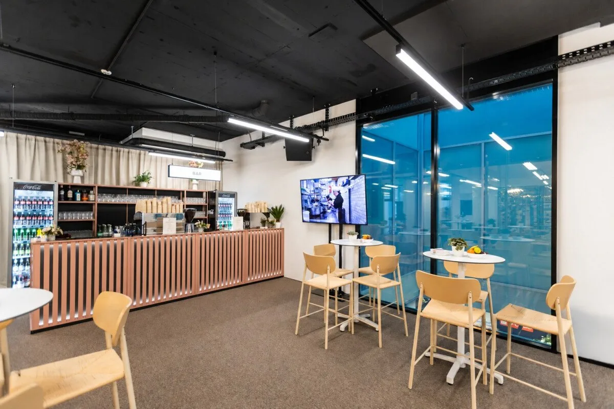 The bar of the Davos Event Lounge with a lit counter and high tables